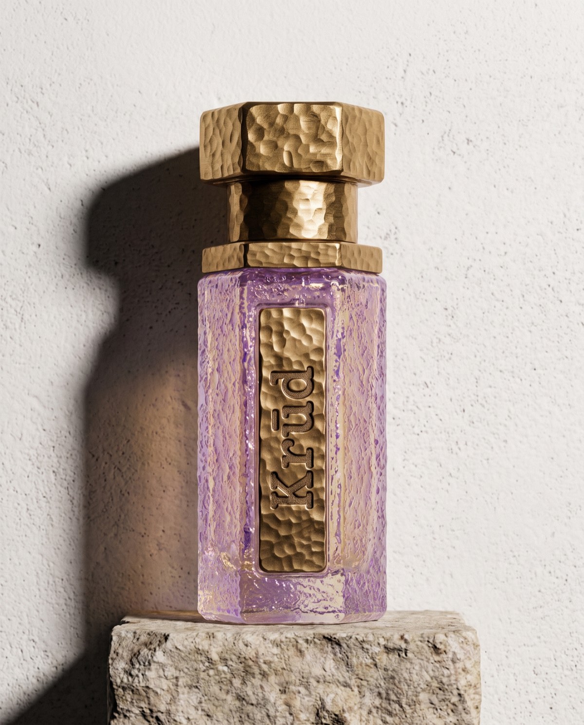 Opal — pale opalescent hammered glass bottle with brass hex cap on stone
