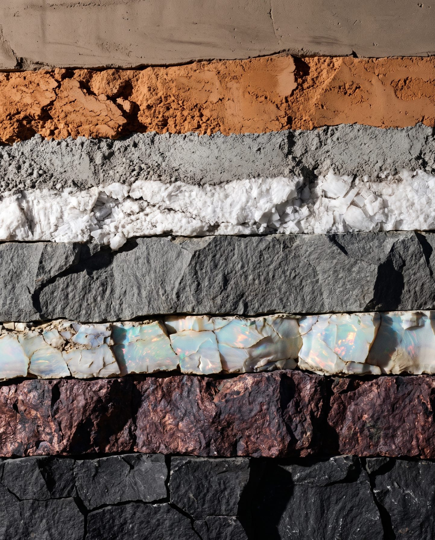 Vertical cross-section of quarry strata, read from black stone to pale surface